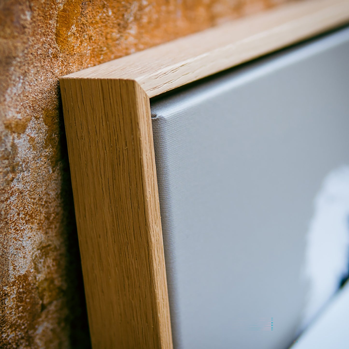 Close-up of a wooden frame corner with a textured wall background
