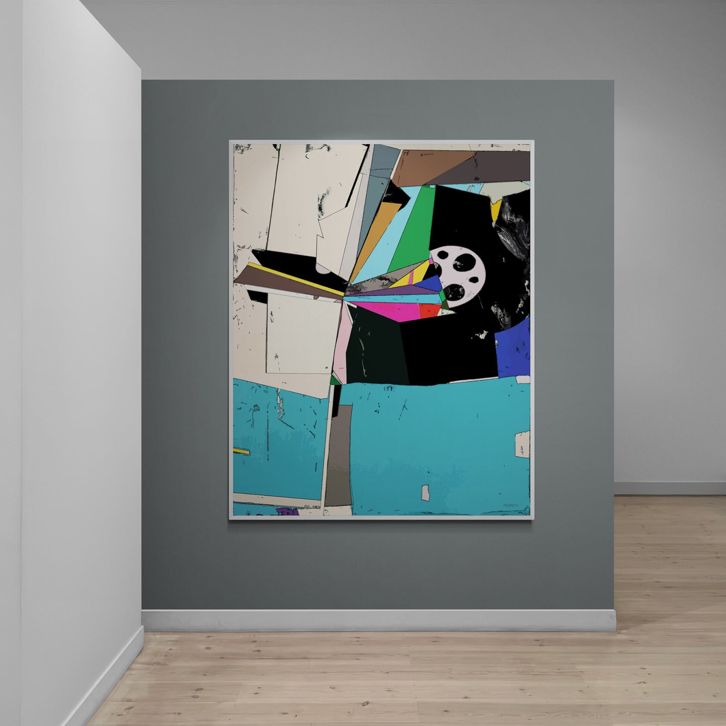 A framed abstract collage artwork with geometric shapes and a film reel motif, displayed on a dark gray wall in a minimalist room with light wood flooring.
