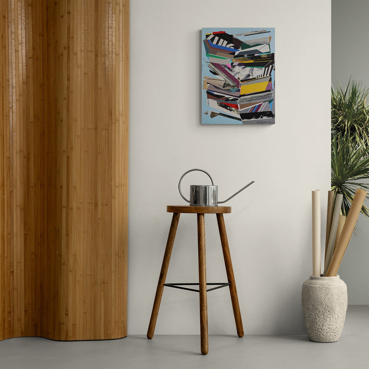 Contemporary art above a wooden stool with a watering can, against a light gray wall.