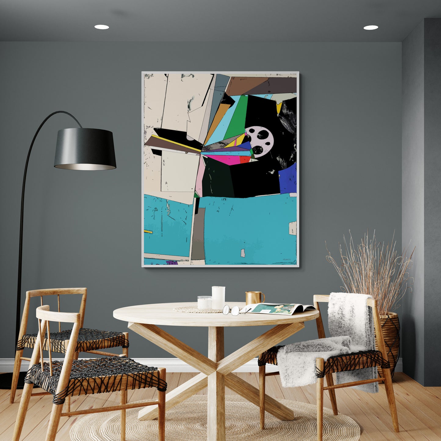A framed abstract geometric wall art print hangs above a round wooden dining table in a modern gray dining room with woven chairs, a black floor lamp, and a woven basket planter.