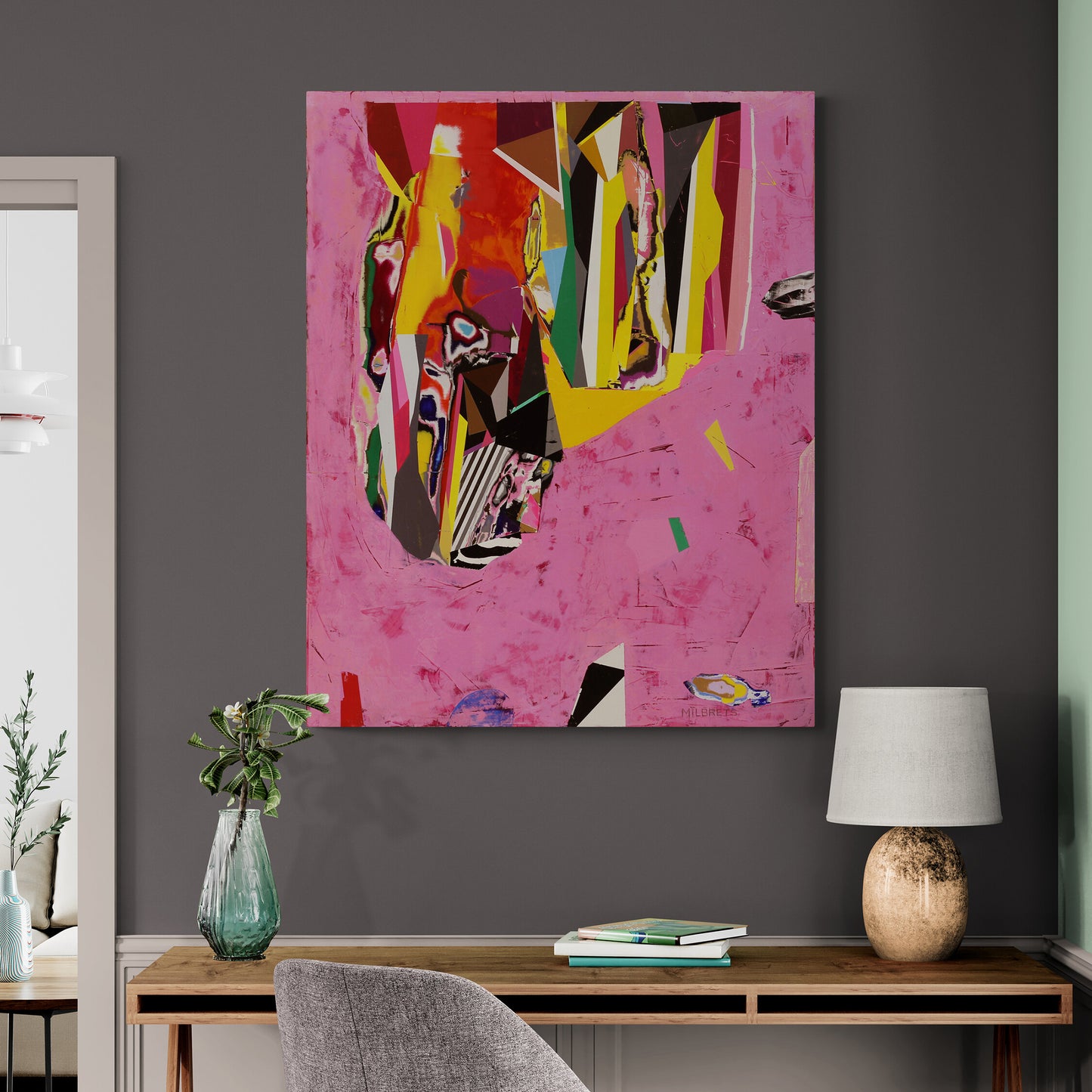 Abstract painting on a gray wall above a wooden console table with a lamp and books.