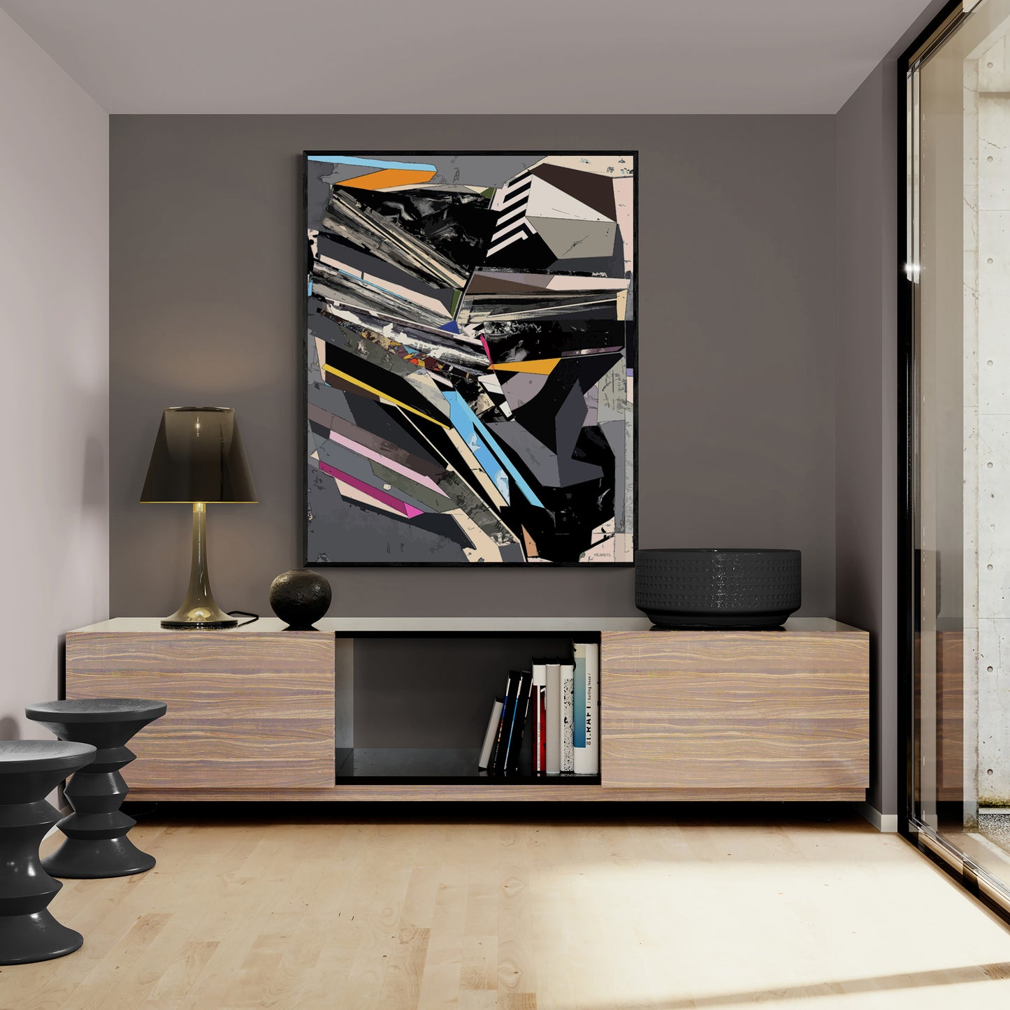 A large framed abstract geometric wall art print with black, white, gray, and orange lines hangs above a modern light wood media console in a minimalist interior room.