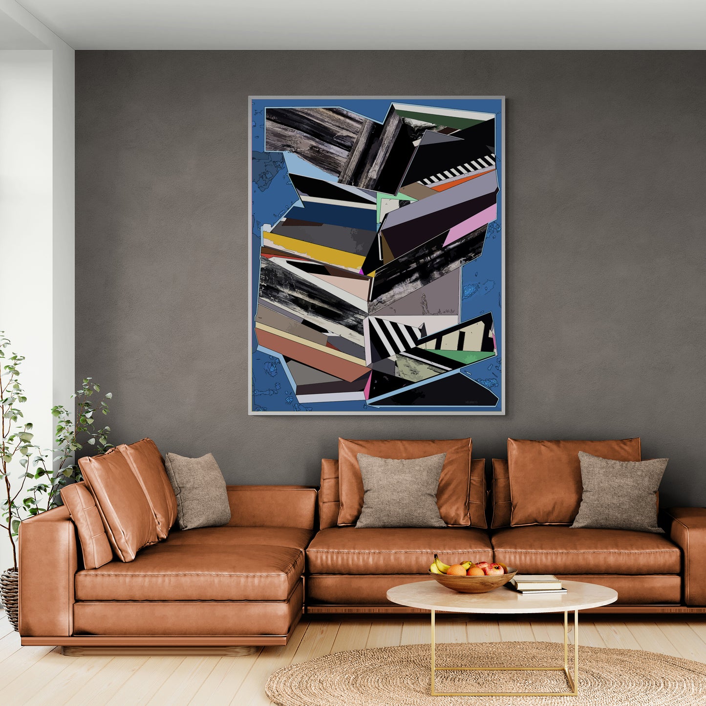 A framed abstract geometric wall art print with a blue background and stacked book-like shapes in black, gray, white, yellow, pink, and brown, displayed above a brown leather sectional sofa in a modern living room.