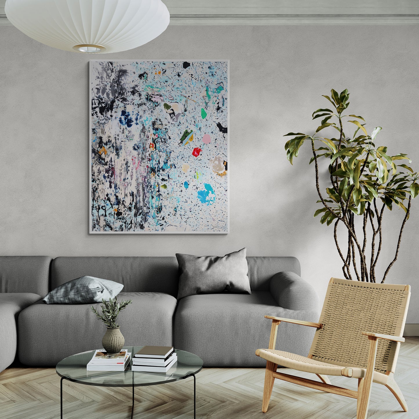 Modern living room with a gray sofa, wicker chair, and abstract artwork on the wall.