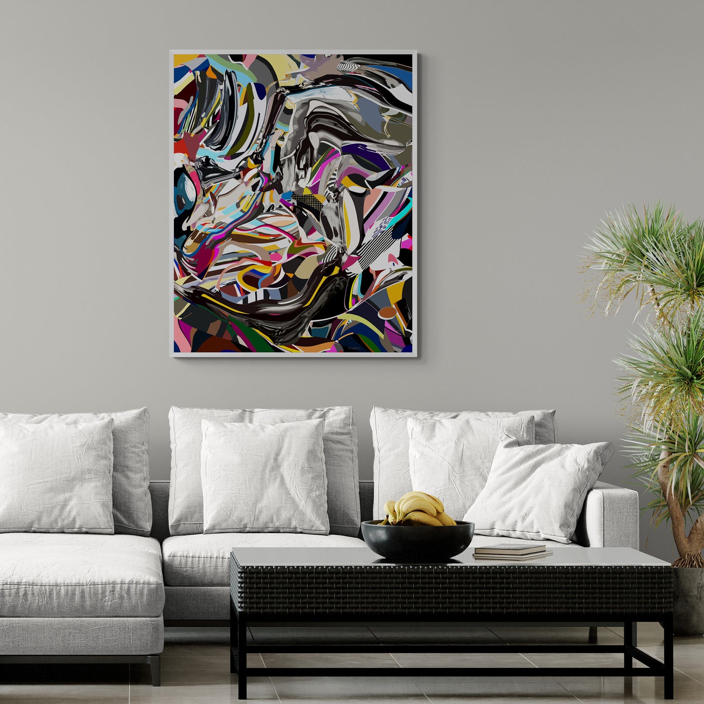 Abstract artwork on a gray wall above a white sofa with decorative items.