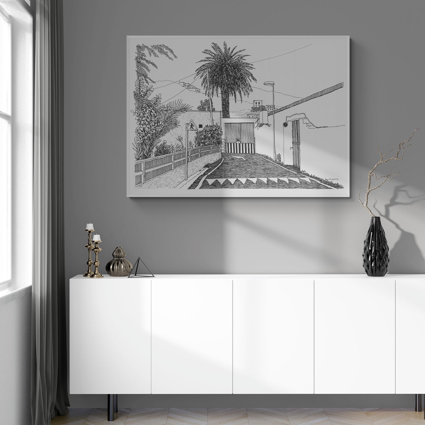 Tropical black and white drawing on a gray wall above a white cabinet.