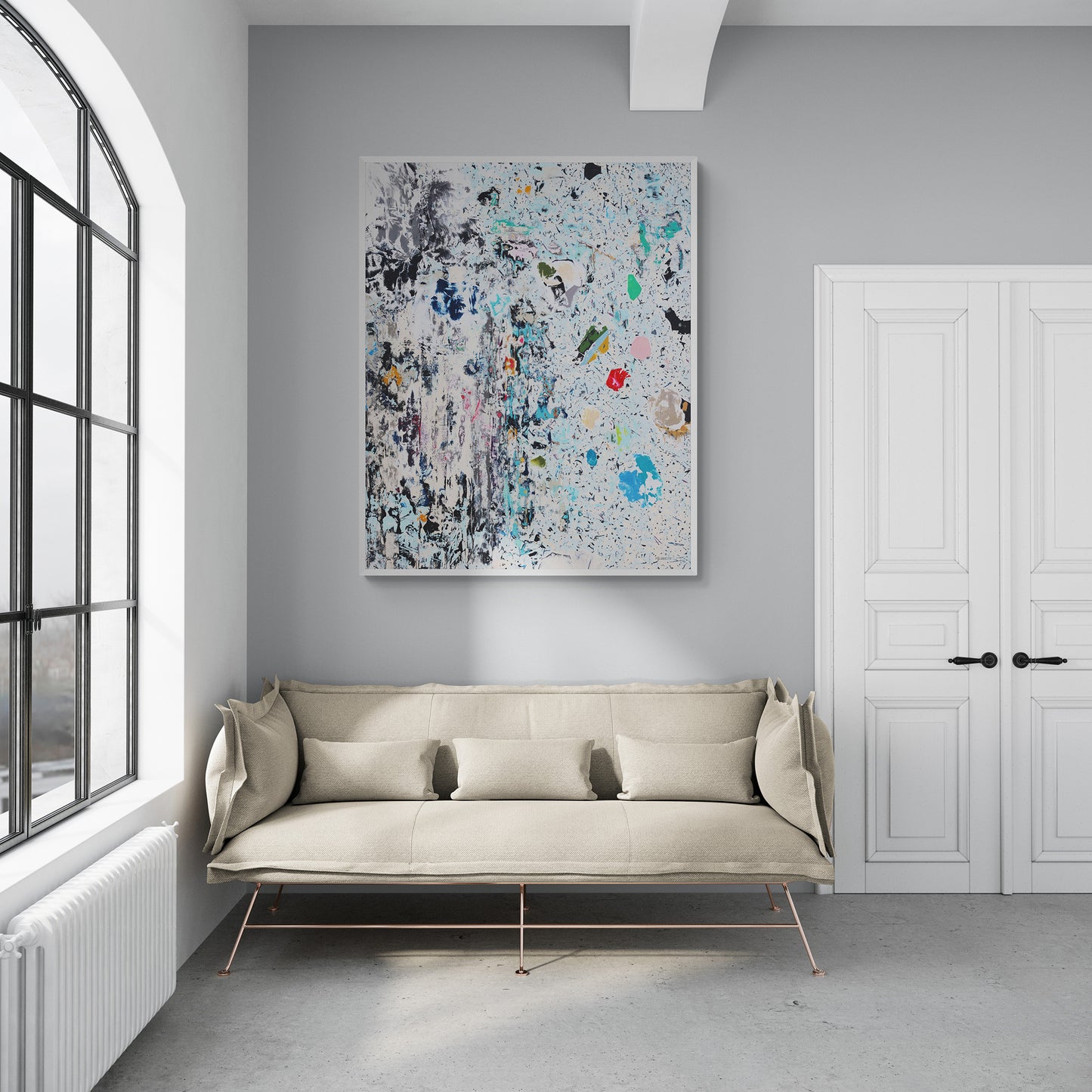 Modern living room with a beige sofa and abstract canvas print on a gray wall.